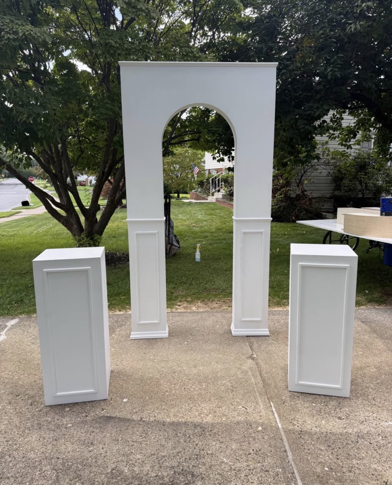 White arch backdrop with two pedestals